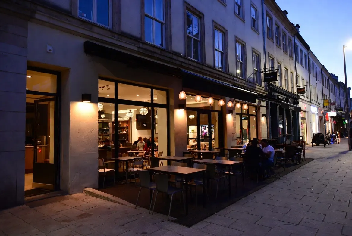 Mokena, IL street scene with local restaurant storefronts, patio seating, and evening foot traffic nearby